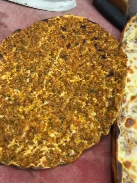 A lahmacun and a sliced pide on the cutting board